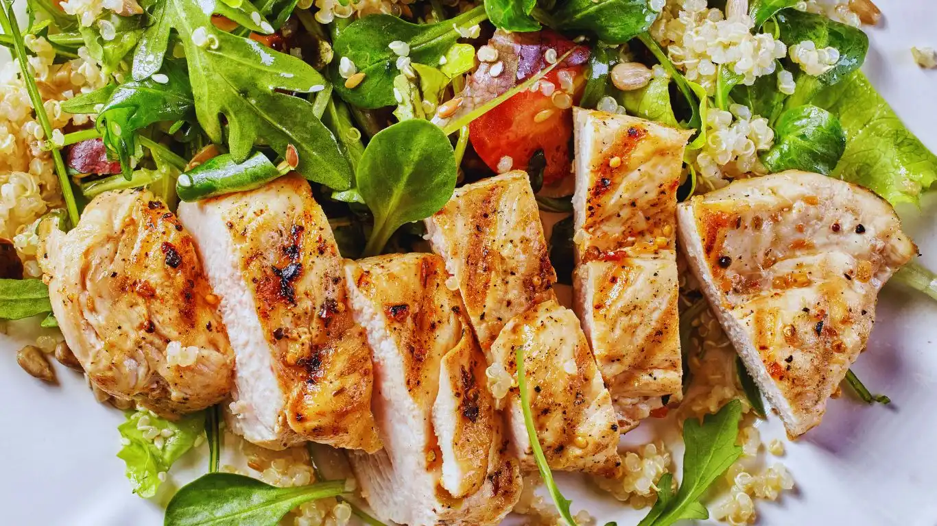 Bowl of Chicken Ranch Salad featuring grilled chicken slices, romaine lettuce, cherry tomatoes, cucumbers, shredded cheese, and a drizzle of creamy ranch dressing